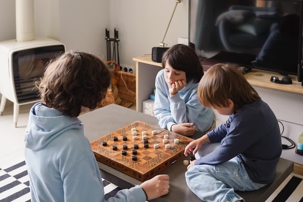 imagem de 3 crianças a jogar damas na sala de estar